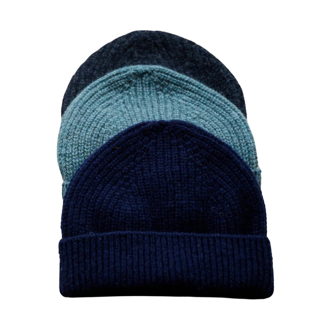 Three stacked knitted beanies in navy blue, teal, and charcoal colors on a white background.