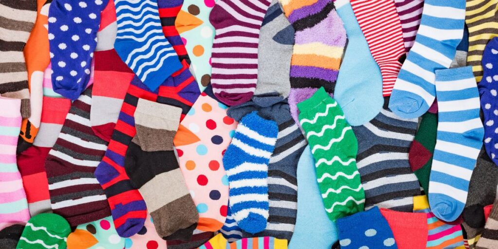 Colorful assorted socks in various patterns and styles arranged flat for a trendy display.