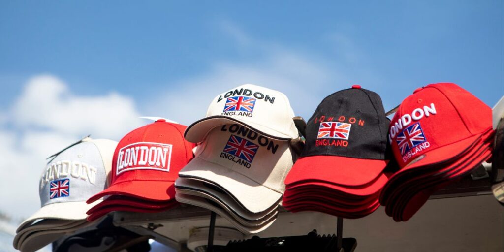 Assorted London England embroidered caps displayed outdoors under a blue sky, showcasing trendy headwear for modern looks.