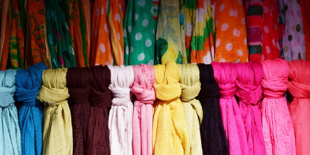 Colorful scarves in a variety of patterns and textures displayed in a row, perfect for all seasons.