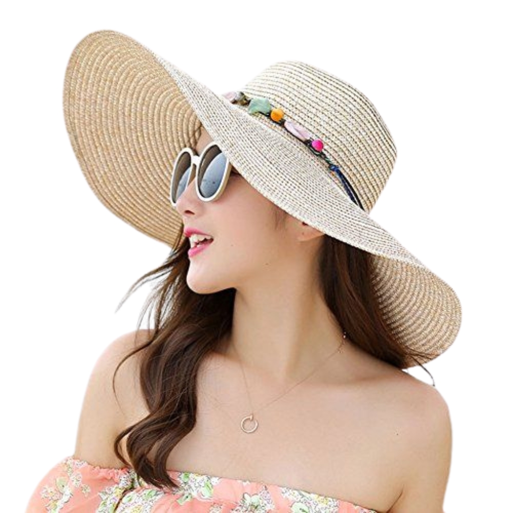"A woman wearing a wide-brim straw beach hat with colorful decorative band, white round sunglasses, and a pink floral off-shoulder dress."

