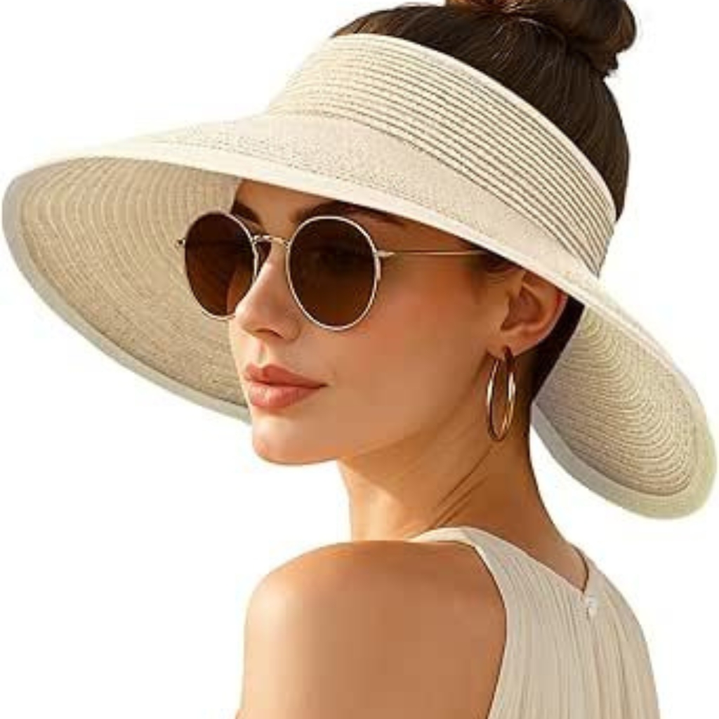 Une femme élégante portant un grand chapeau à visière tissé de couleur crème, des lunettes de soleil rondes et des boucles d'oreilles créoles en or. Elle est légèrement tournée sur le côté, mettant en valeur le large bord du chapeau et son look estival chic. 