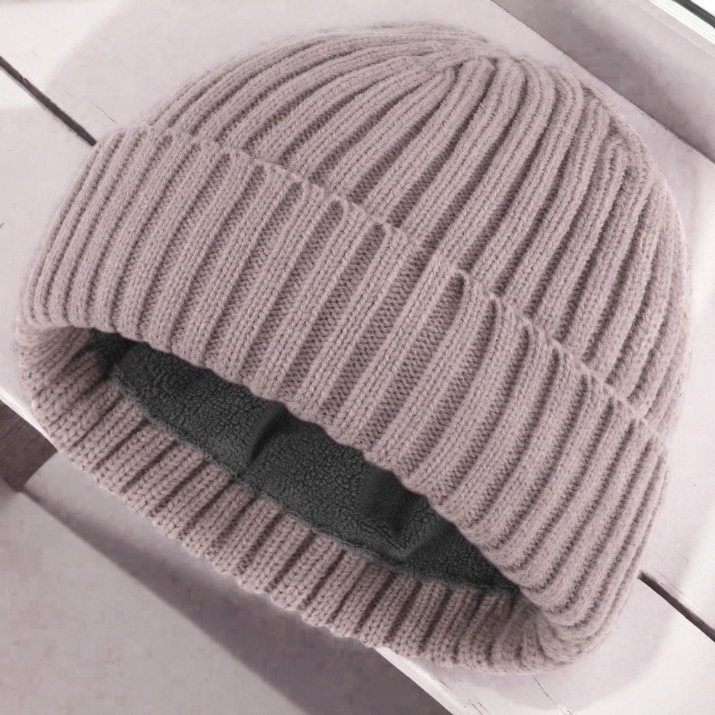 A light gray cuffed beanie with a soft fleece interior visible at the opening, resting on a light surface.