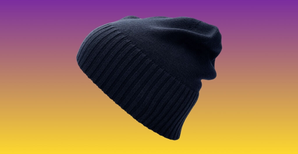 A navy blue Fine knit beanie hat with a folded brim, shown against a gradient background that shifts from purple at the top to yellow at the bottom.