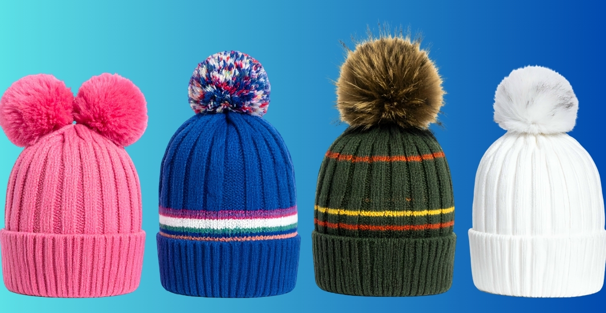 A row of four knit beanies with pom-poms in pink, blue, green with stripes, and white, set against a blue gradient background