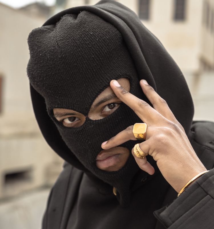 Man wearing a black 100% cotton balaclava with stylish gold rings and black hoodie