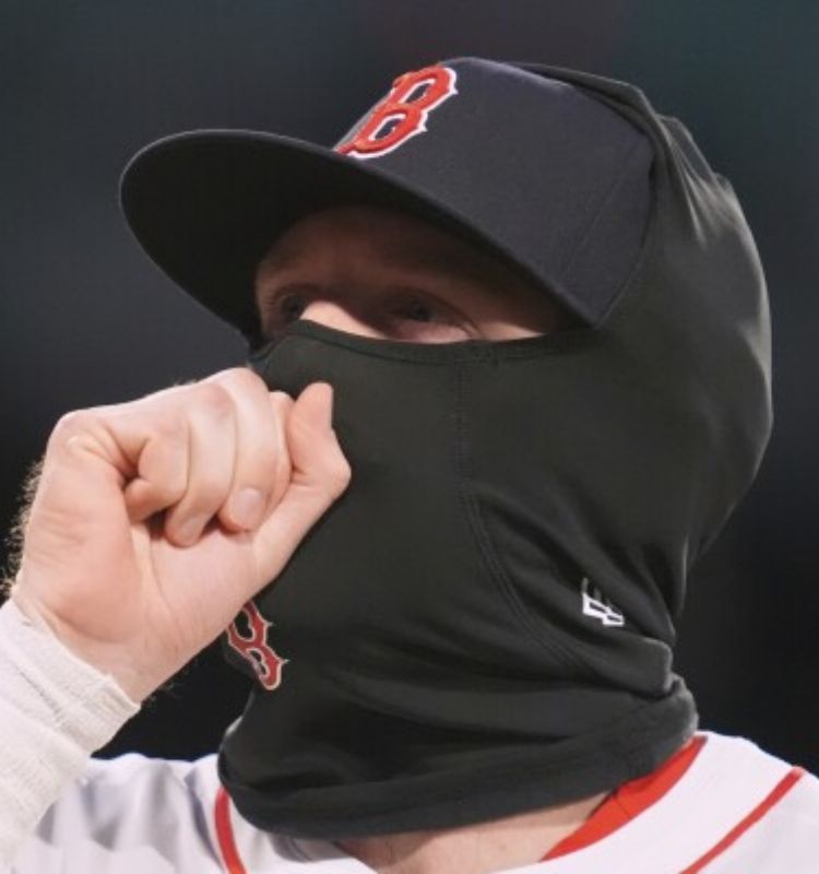 Baseball player wearing a black balaclava and cap during a cold weather game