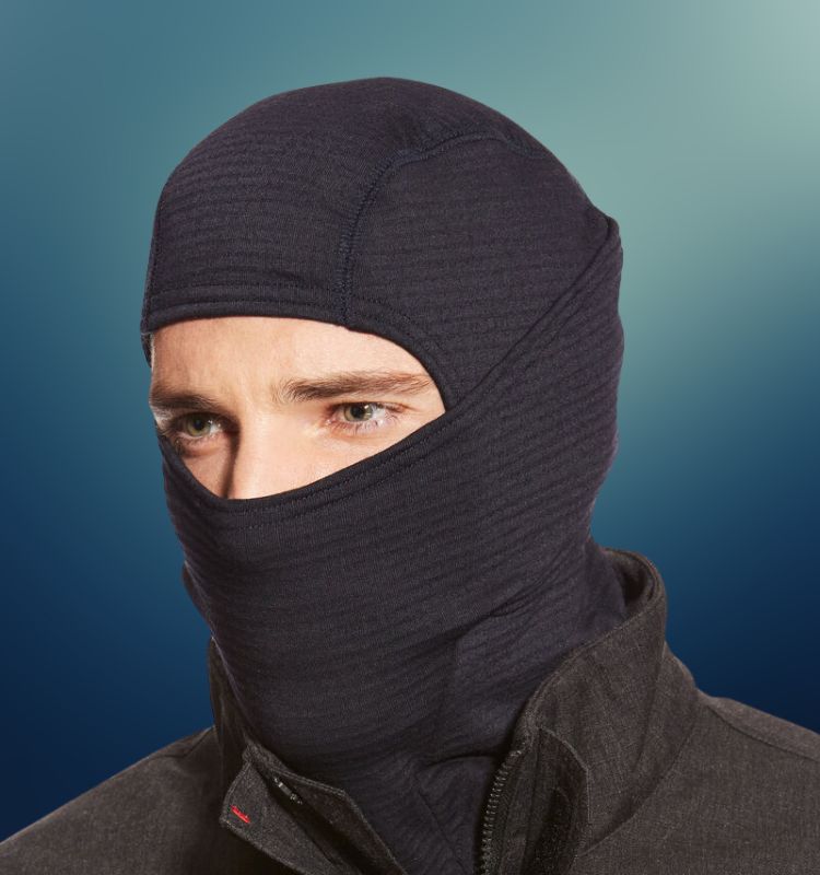 Man wearing a flame-resistant black balaclava for winter work and fire safety protection.