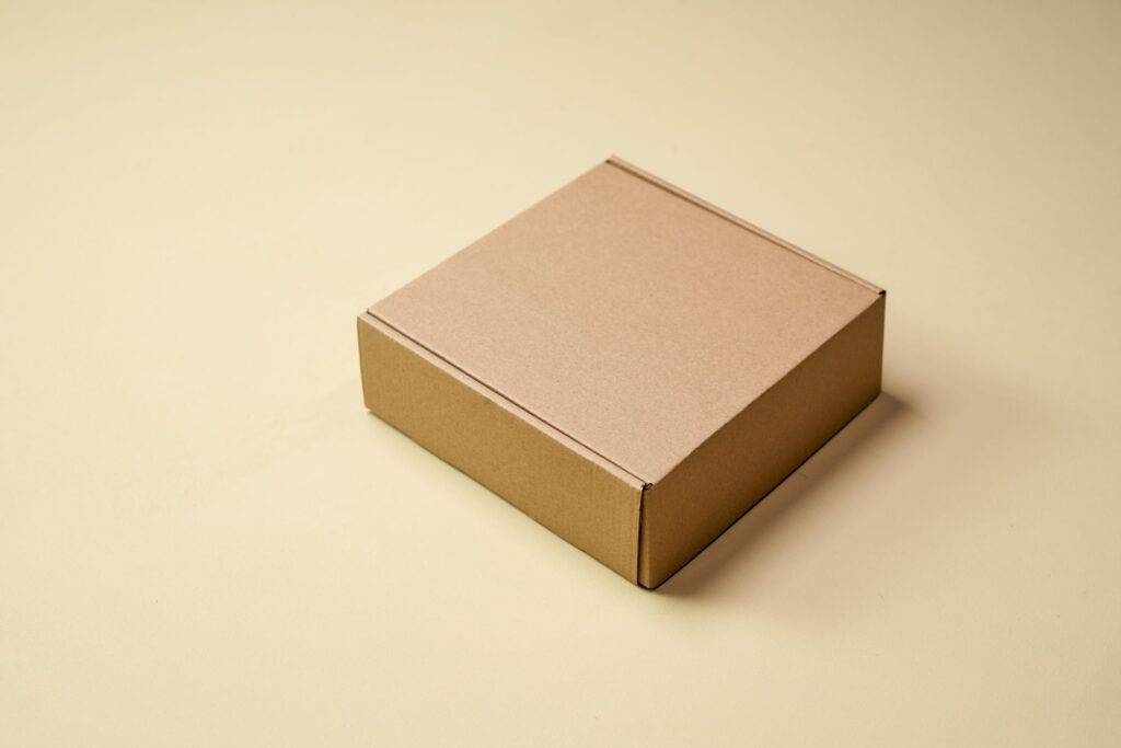 Boîte en carton kraft brun neutre sur fond beige