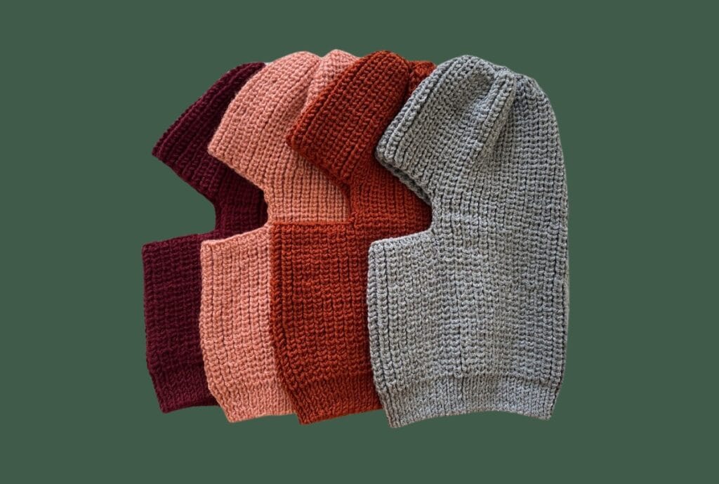 Close-up of knitted and ribbed winter balaclavas showing textured patterns.