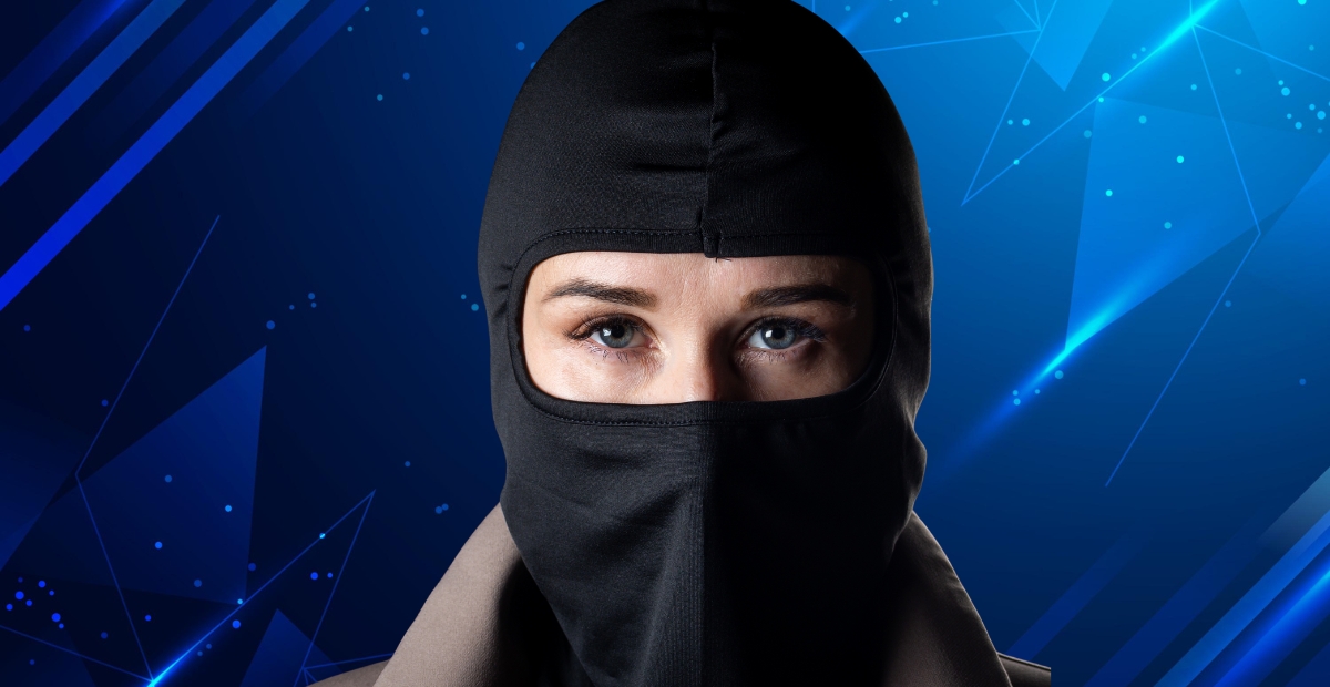 Eine Person, die eine schwarze Sturmhaube trägt, die den größten Teil ihres Gesichts bedeckt und nur die Augen sichtbar lässt, vor einem blauen geometrischen Hintergrund.