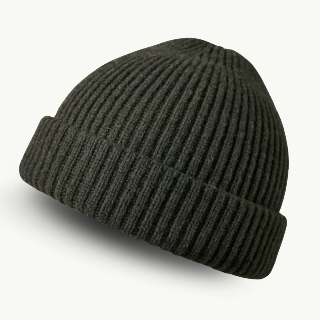 Close-up of a dark gray ribbed fisherman beanie with a folded cuff, showing texture and stitching typical of knit hats.
