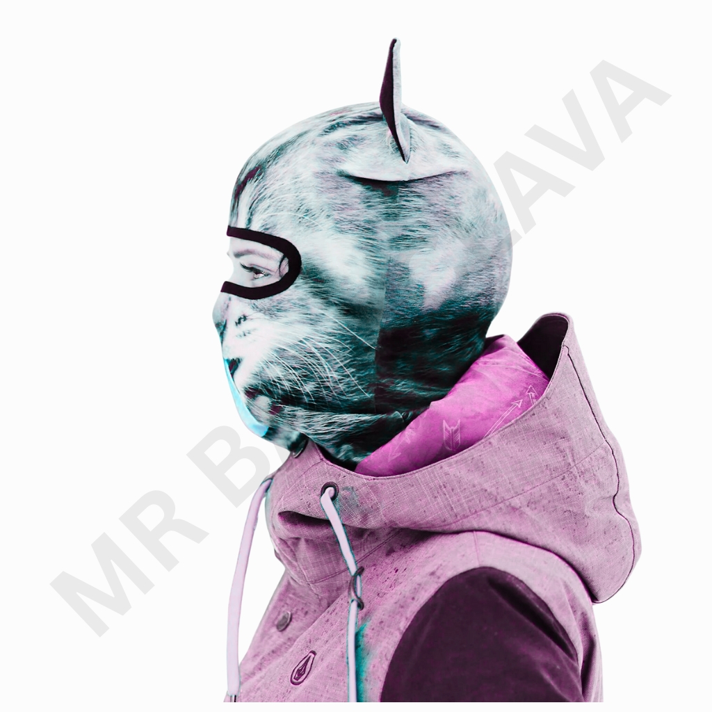 Person wearing a printed cat/animal-face balaclava with eye cutout and horn-like features, paired with a pink and teal hooded jacket.