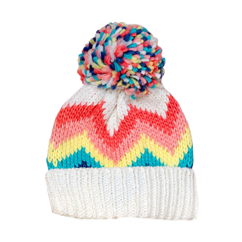 A colorful knit beanie with a large multicolor pom-pom, featuring a zigzag pattern in pink, yellow, teal, and white, and a white ribbed cuff.