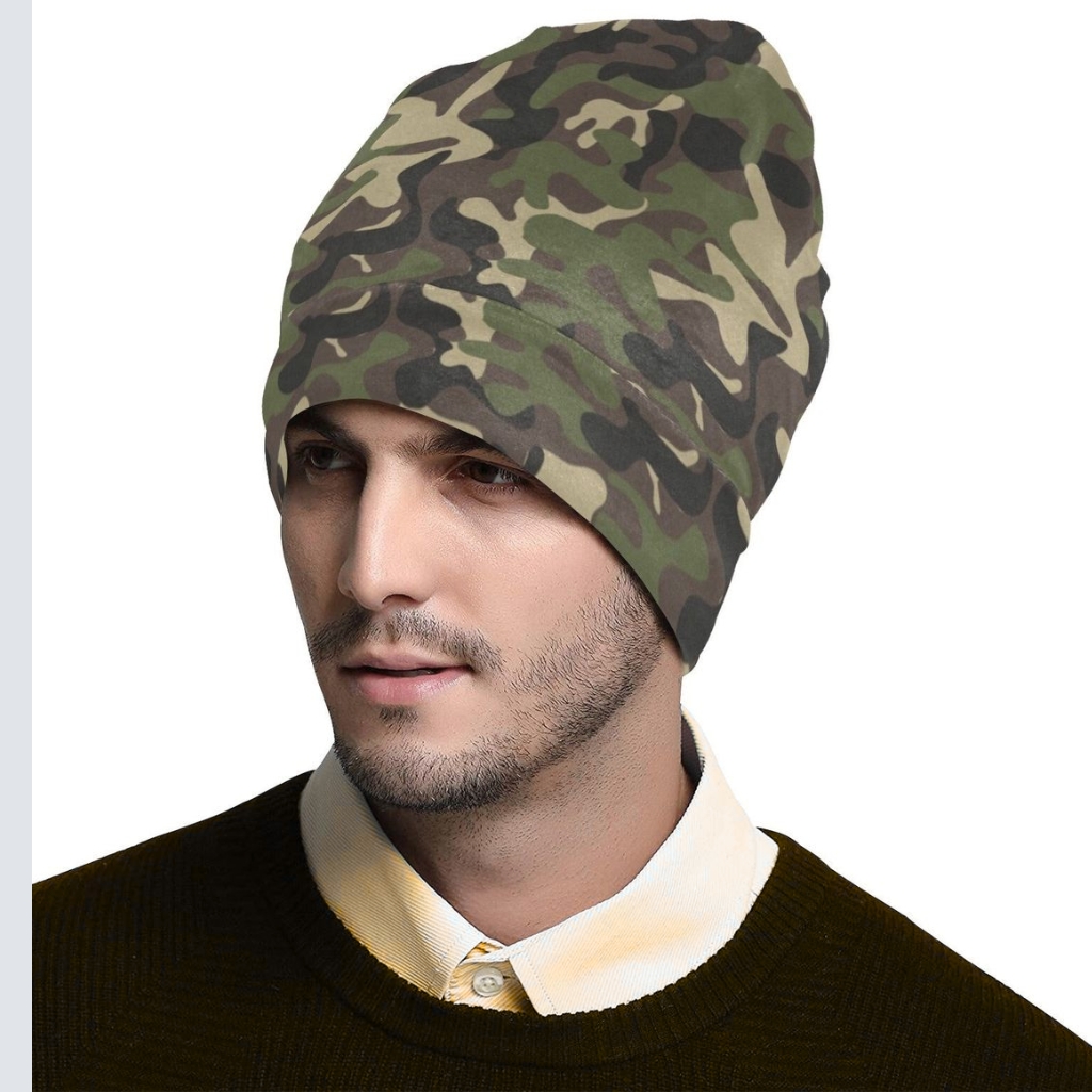 A man wearing a camouflage-pattern beanie folded at the rim, paired with a dark sweater and cream shirt, showcasing camouflage beanies as a stylish outerwear accessory.