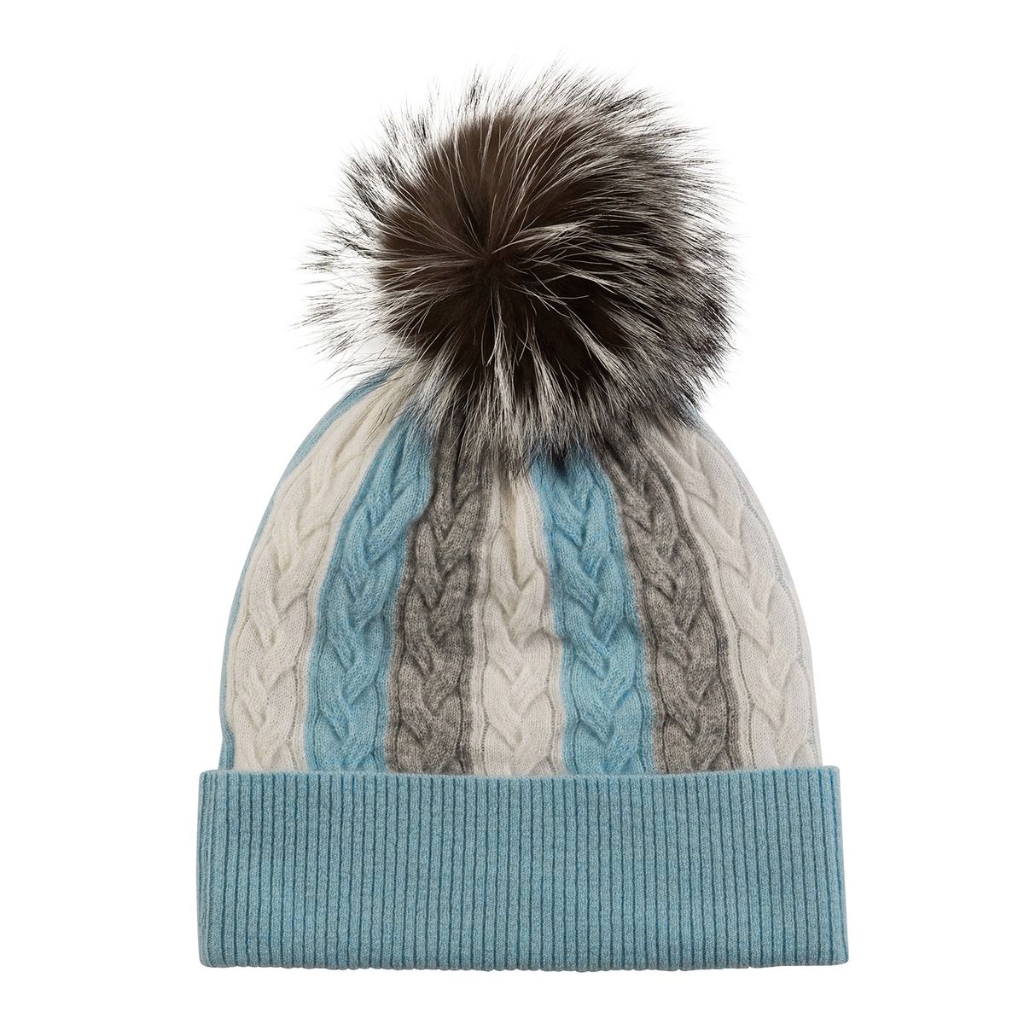 Blue and cream knit wool beanie with a wide ribbed cuff and a large faux fur pom-pom on top.
