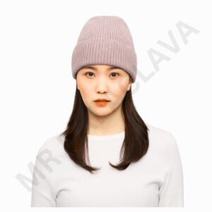 A woman with straight dark hair wearing a light pink knitted beanie and a white top, facing forward with a neutral expression.