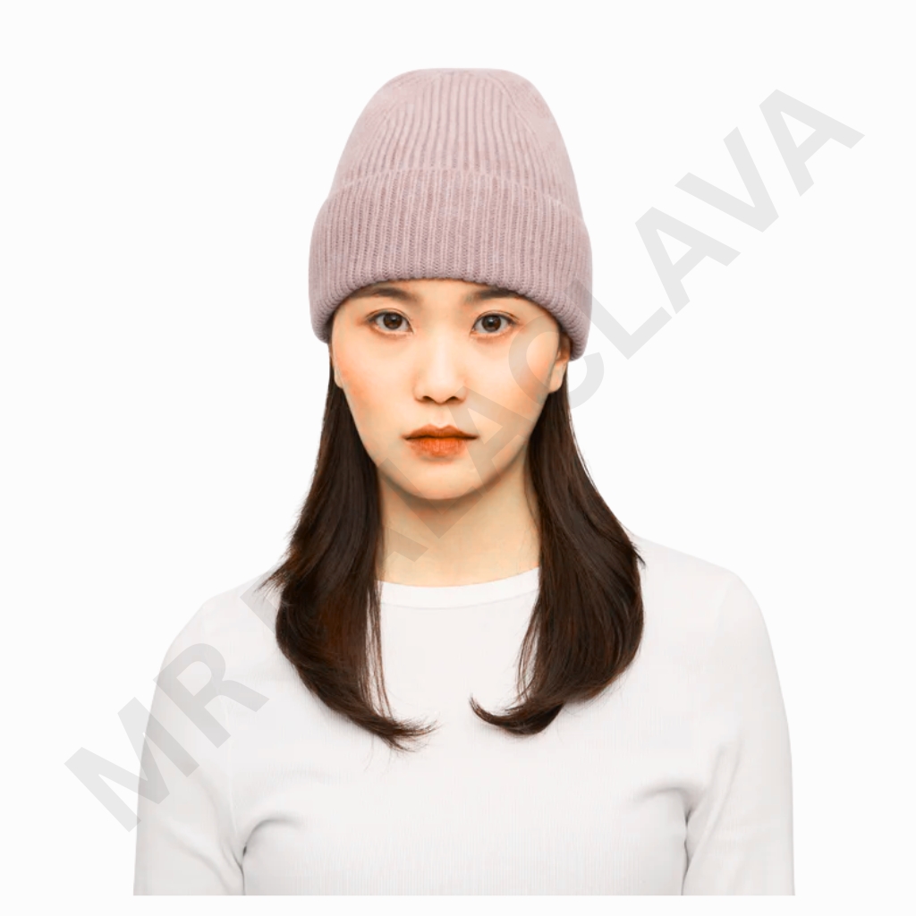 A woman with straight dark hair wearing a light pink knitted beanie and a white top, facing forward with a neutral expression.