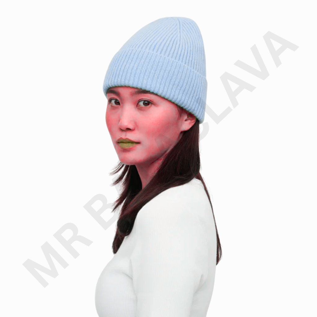 A woman with long dark hair wearing a light blue knitted beanie and a white top, facing slightly to the left with a neutral expression.