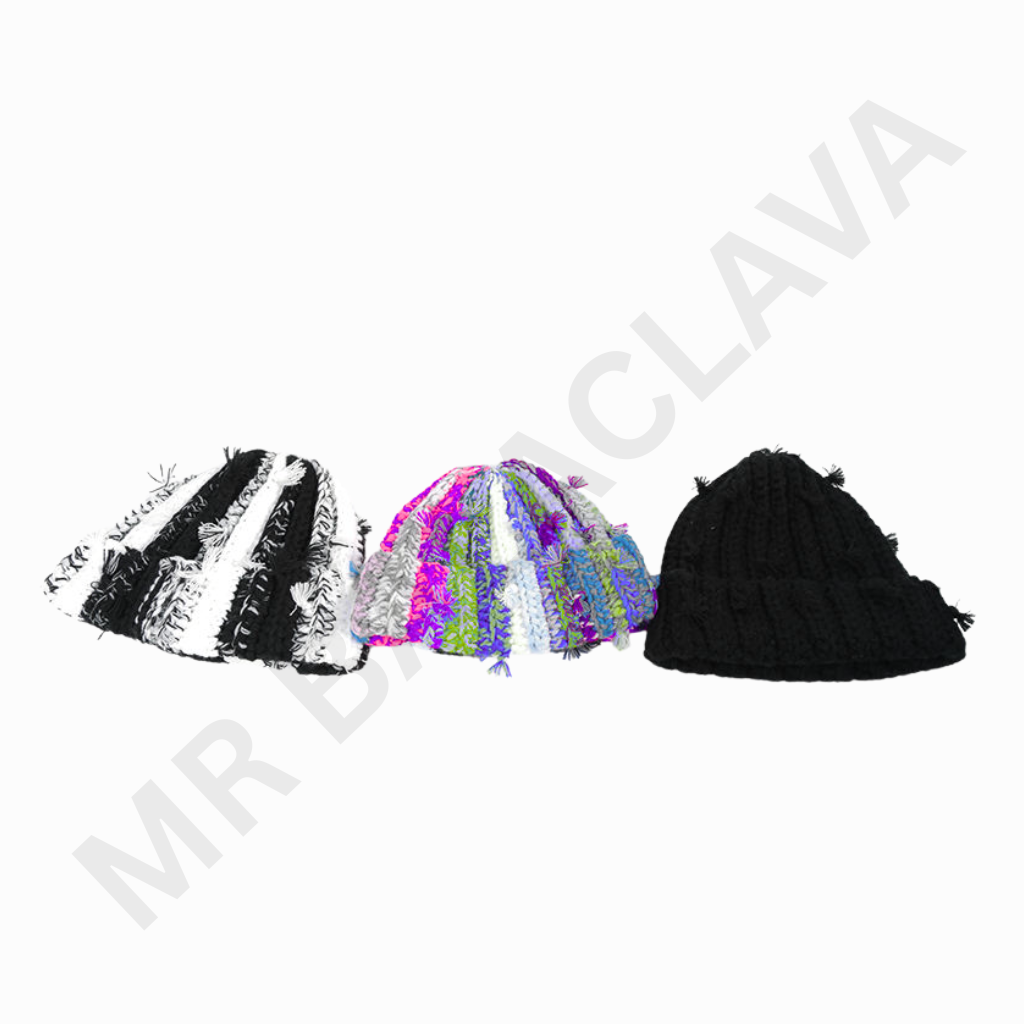 A row of knitted beanies laid out in a line. From left to right: a black-and-white striped beanie, a multicolor pastel beanie, and a solid black beanie in the foreground with a plain white background.