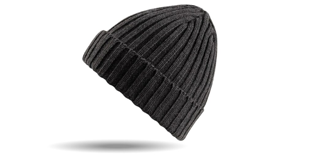 Dunkelgraue Strickmütze mit geripptem Muster und umgeschlagenem Rand, leicht schräg geschnitten und mit einem weichen Schatten darüber.