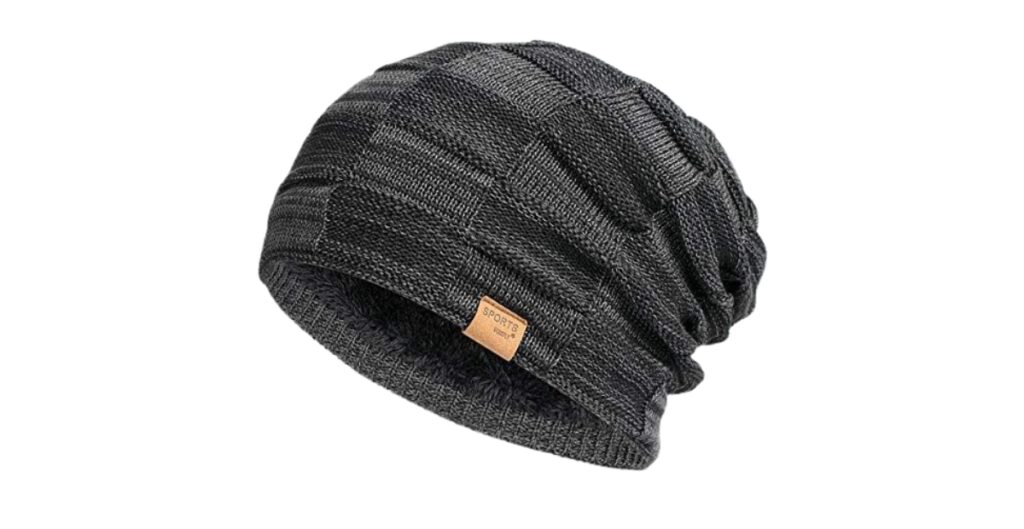 Eine dunkelgraue Strickmütze mit einem kleinen hellbraunen Etikett auf der Vorderseite.