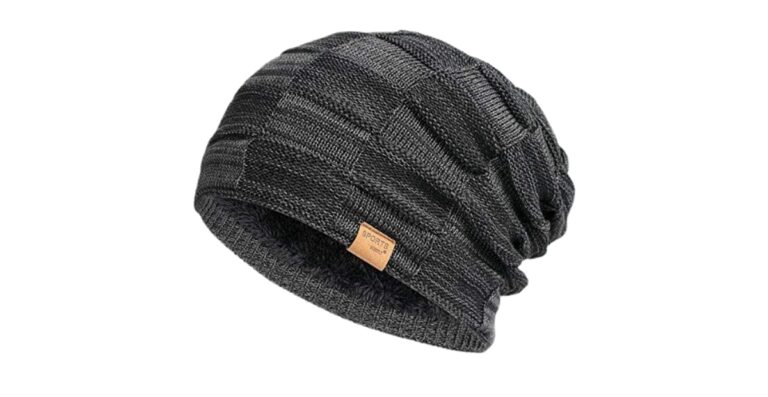 Eine dunkelgraue Strickmütze mit einem kleinen hellbraunen Etikett auf der Vorderseite.