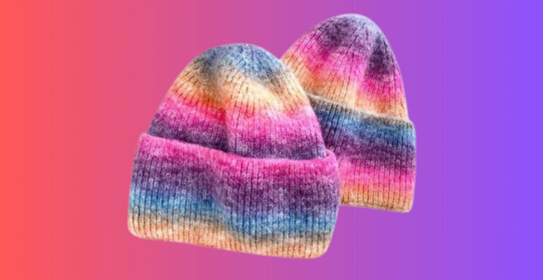 Zwei Strickmützen mit einem Ombré-Regenbogenverlauf von Rosa zu Violett vor einem Hintergrund mit einem Farbverlauf von Rosa zu Violett.
