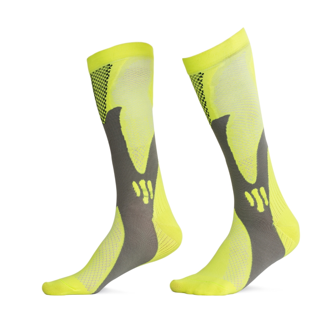 A pair of neon yellow knee-high ski socks with dark gray accents and a geometric pattern, shown side by side on a white background.