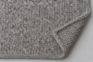 Heather-grey acrylic and wool knit swatch with a folded corner