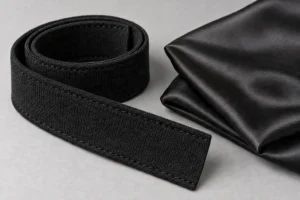 Cap Sweatband & Lining Fabrics: coiled black sweatband beside folded satin lining