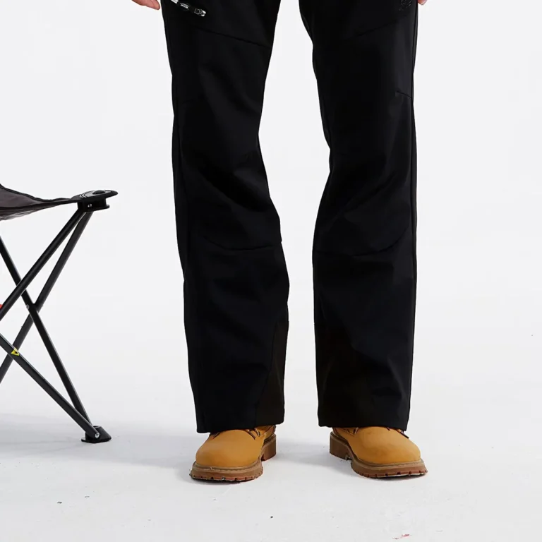 Black stretch ski pants worn with a red jacket, studio photo