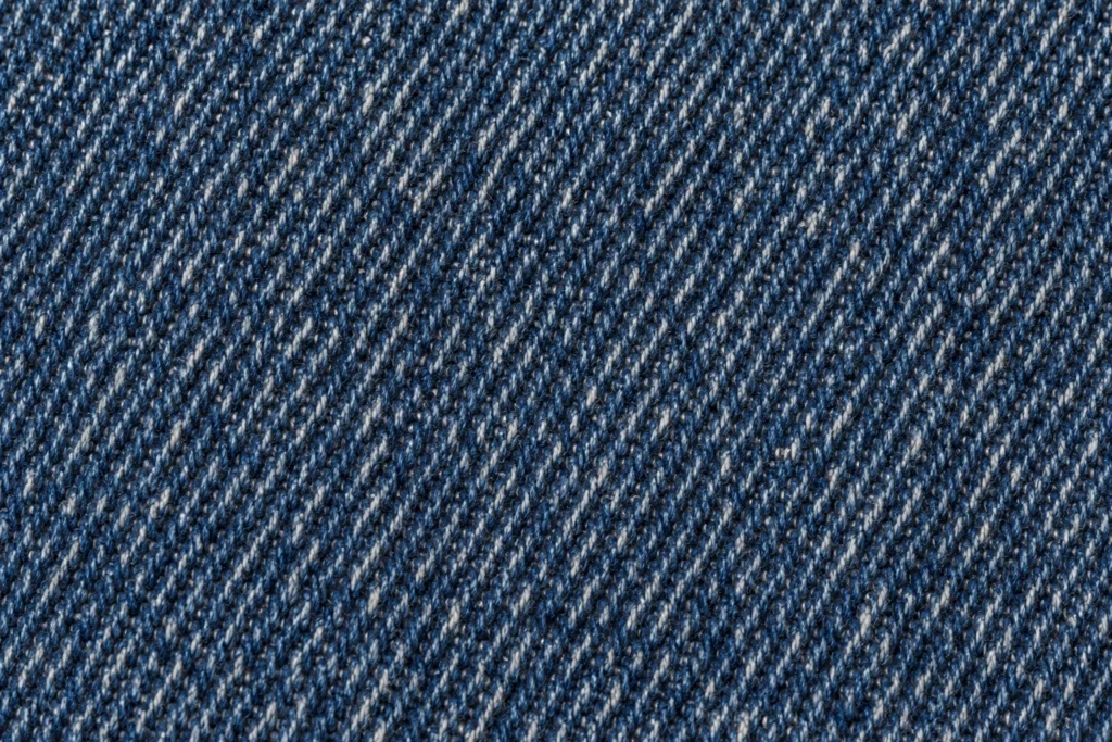 Denim (Cap Fabric): close-up of indigo denim twill with blue and white yarns