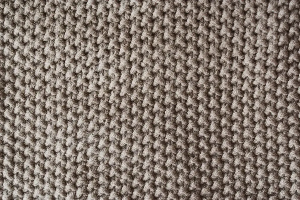 Nahaufnahme eines braun-cremefarbenen Strickstoffs