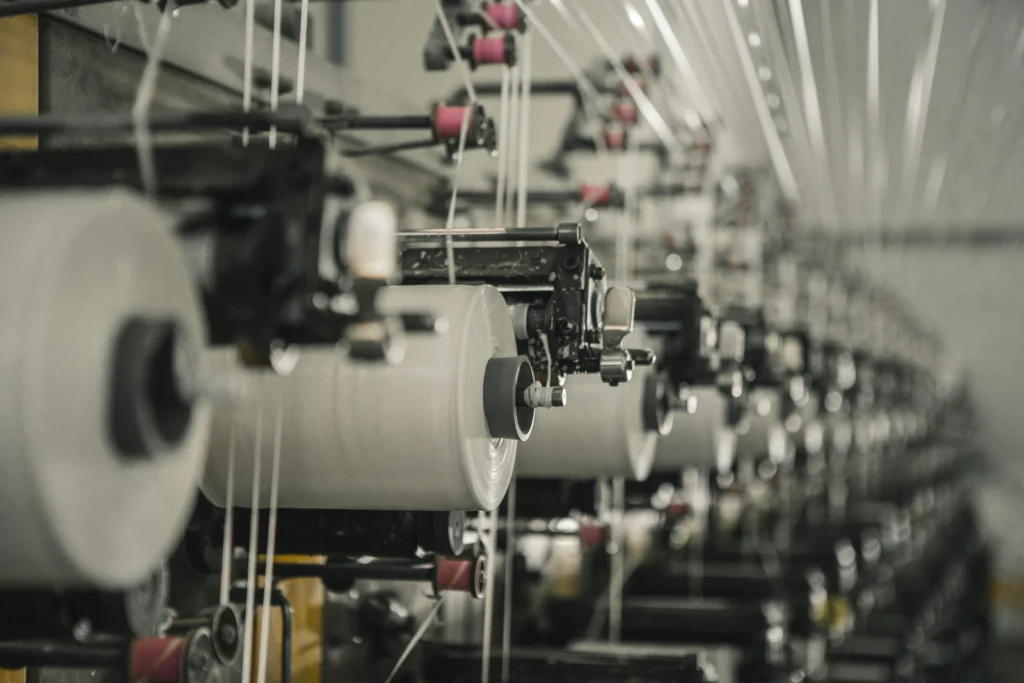 Rows of yarn cones feeding industrial knitting machines