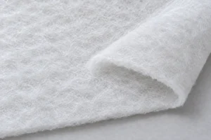 Ouate polyester (rembourrage) : nappe d’ouate polyester blanche dont le bord coupé montre le gonflant