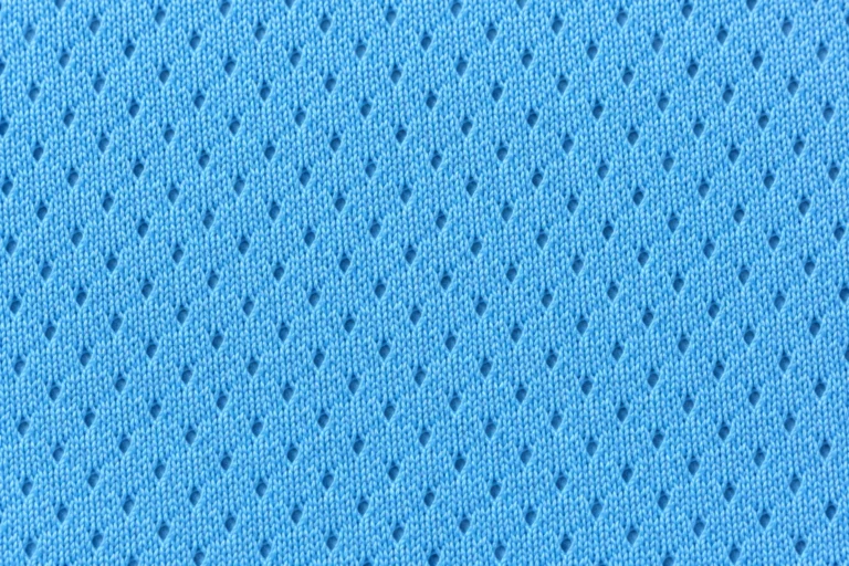 Close-up of sky-blue bird's-eye mesh with tiny eyelets in a diagonal pattern