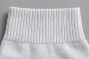 Elastic Covering Yarn (Nylon/Spandex): close-up of the elastic ribbed top band of a white sock