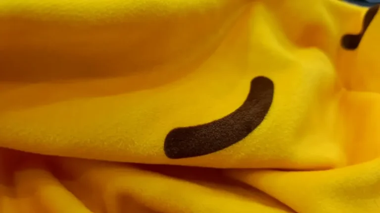 Close-up of yellow stretch velvet with a dark brown printed curve, showing the soft short pile