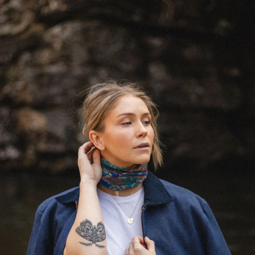 Mujer con una braga de cuello estampada y una chaqueta azul