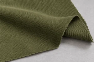 Peached Polyester Twill (Peach Skin): olive peached polyester twill swatch with a folded corner