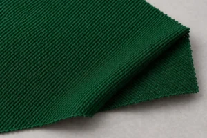 Sergé polyester-coton (65/35) : échantillon de sergé polyester-coton vert bouteille avec un coin replié