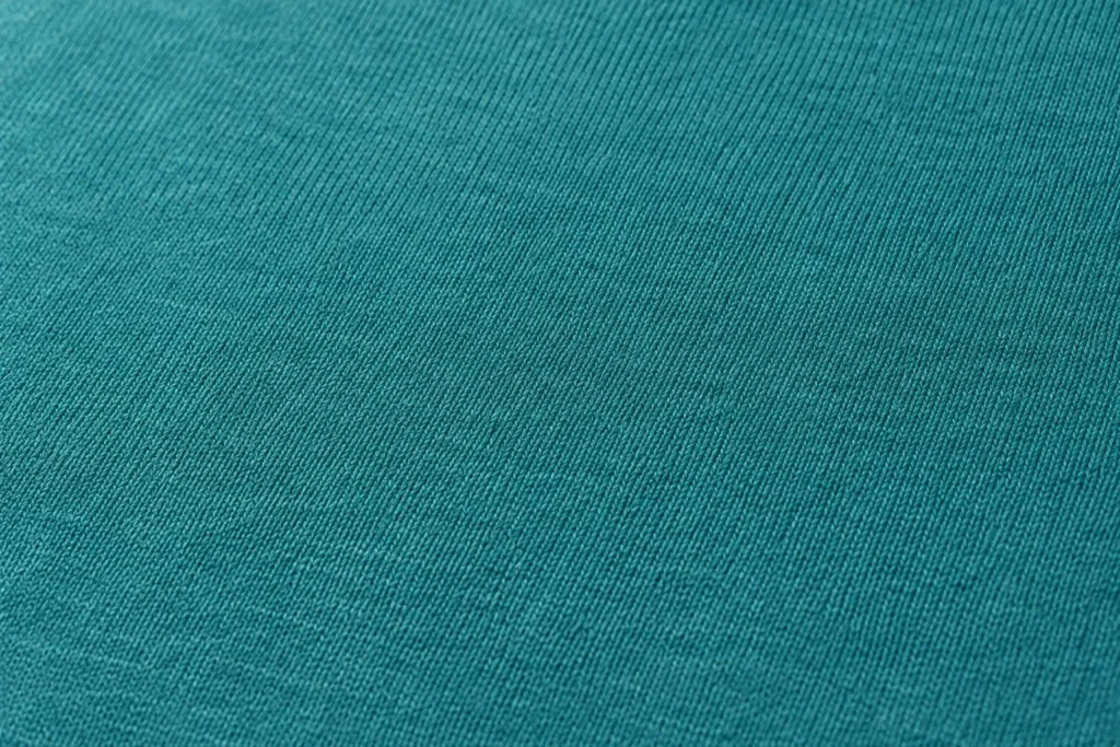 Primer plano de punto de microfibra de poliéster verde azulado con una superficie lisa y suave