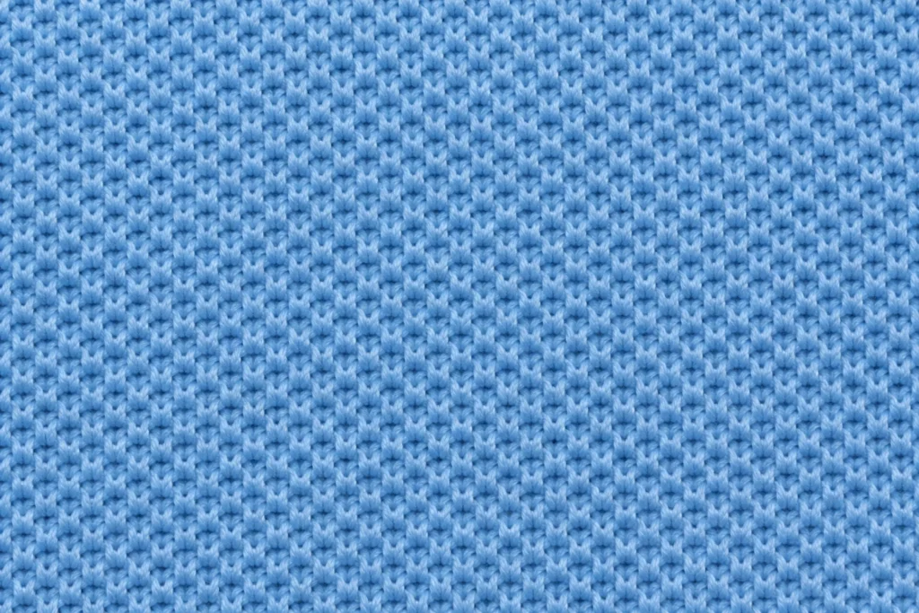 Primer plano de piqué de poliéster azul cielo con una fina textura de nido de abeja en relieve
