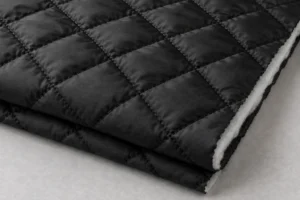 Schwarzes gestepptes Nylon, dessen Wattierungslage an der Schnittkante sichtbar ist