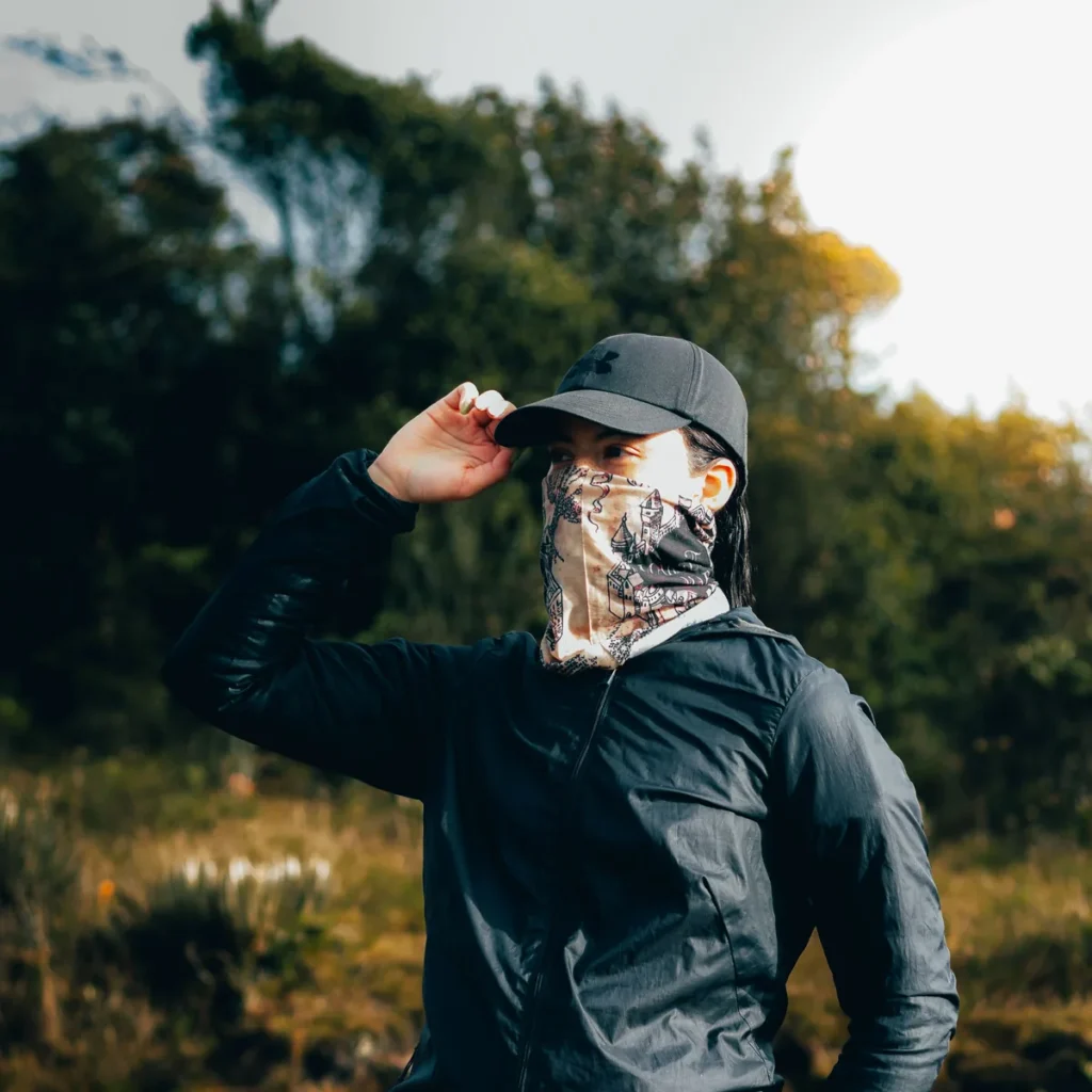 Printed neck gaiter worn over the nose and mouth on a hike