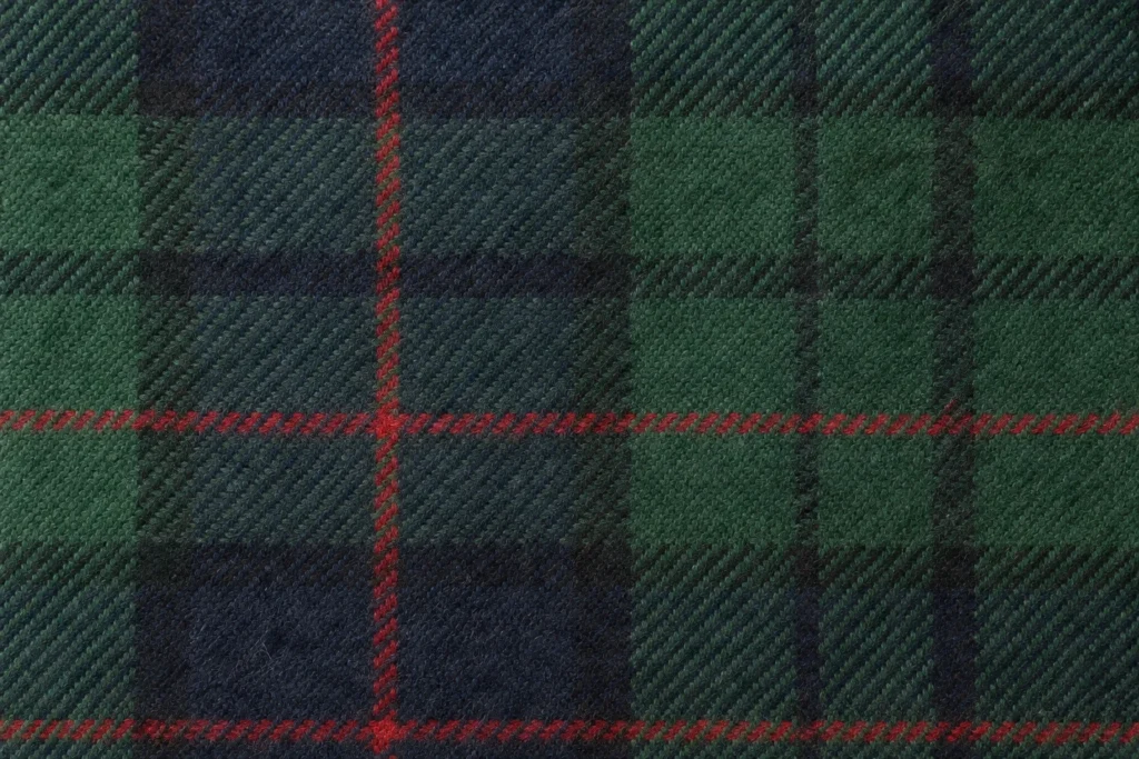 Gewebte Wolle und Merinowolle (Karos und Tartans): Nahaufnahme von grün-marineblauem Schalstoff aus gewebter Wolle mit Tartanmuster